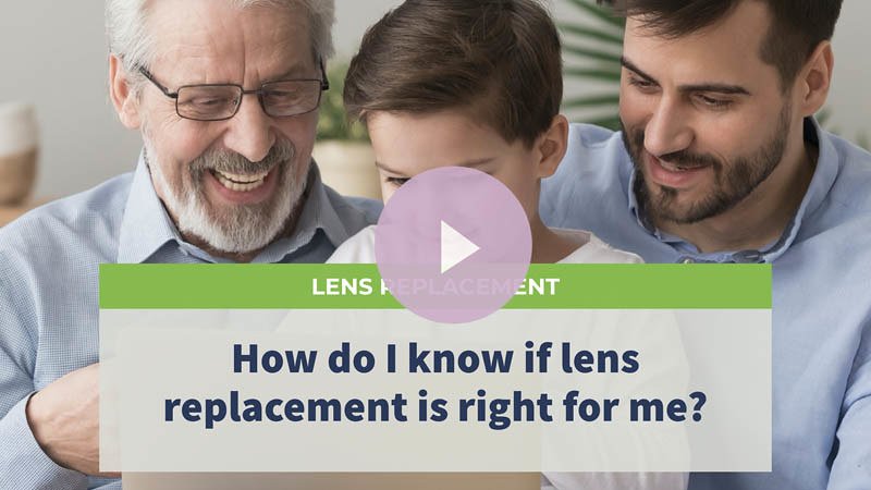 A senior man, his son, and grandson sitting on a sofa, looking at an iPad and laughing.