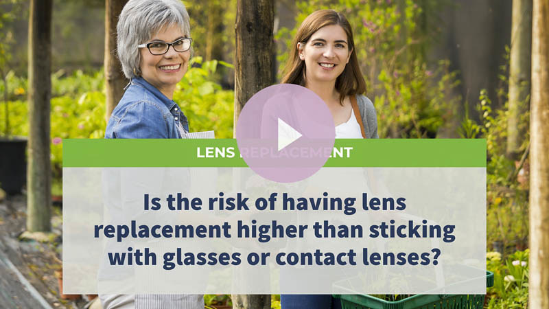 A senior mother with glasses standing in a garden with her daughter.