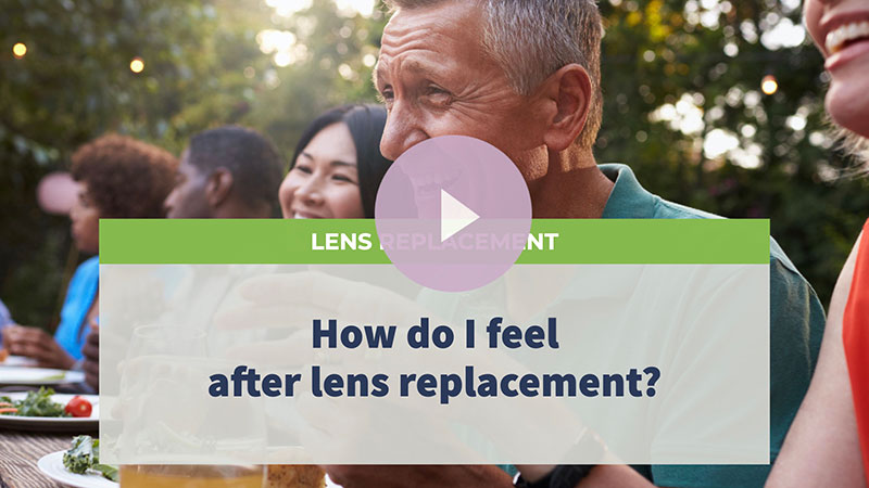 A senior man wearing a green shirt laughs while having an outdoor dinner with friends.
