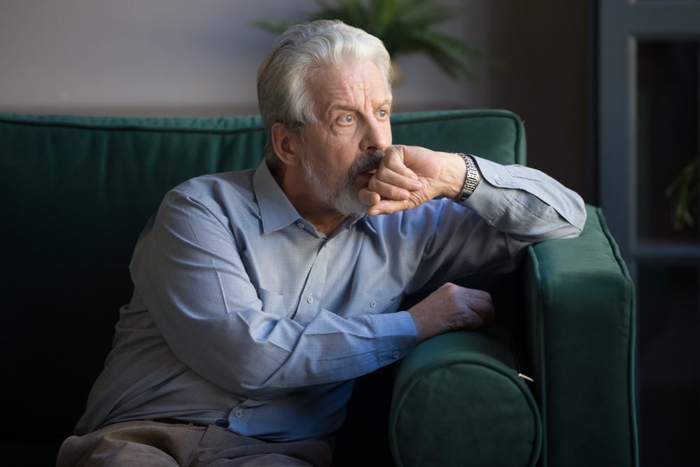 Sixty,Years,Old,Mature,Man,Sitting,Alone,On,Couch,At